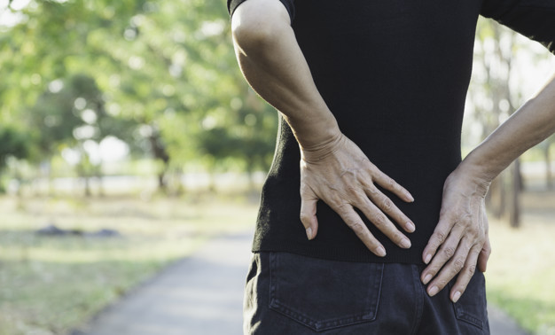 A woman suffering from backache, spinal injury and muscle issue