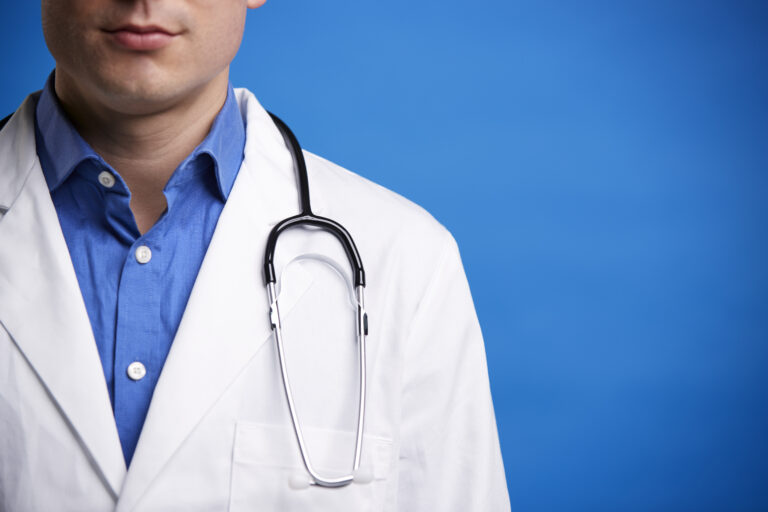 Young white male doctor with stethoscope, cropped portrait