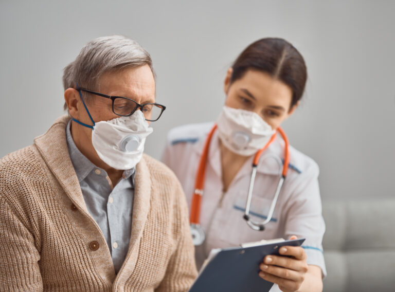 Doctor and senior man wearing facemasks