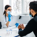 A female doctor consults her patient and holds documents in her