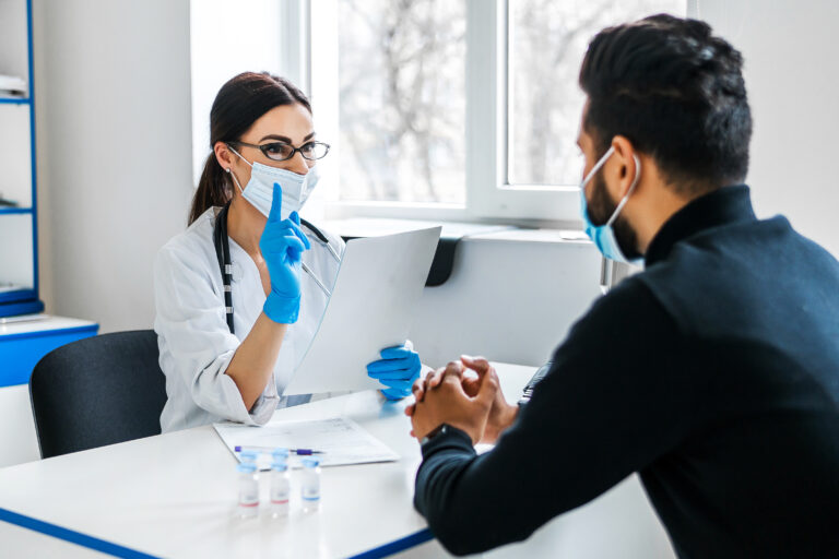 A female doctor consults her patient and holds documents in her