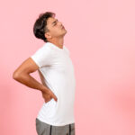 front-view-young-male-having-backache-on-pink-background-color-model-emotion-male